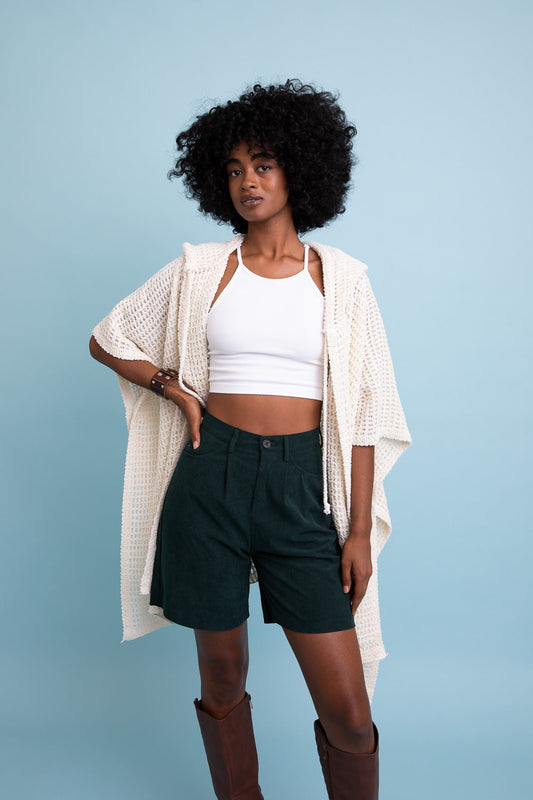 Leto Collection boho waffle ruana with hood in cream color, styled with a crop top and shorts