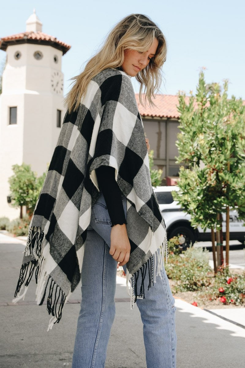 Leto Collection buffalo check ruana featuring black and white check pattern and fringed edges