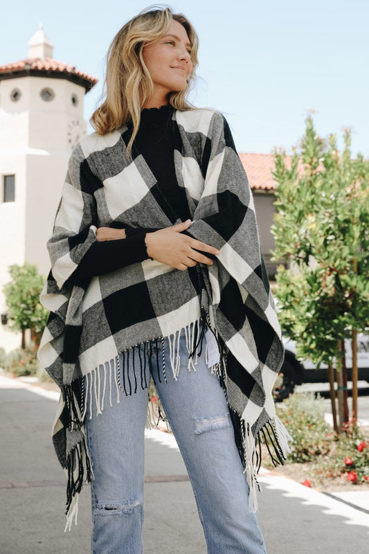 Stylish buffalo check ruana from Leto Collection featuring fringe detail and a cozy fit