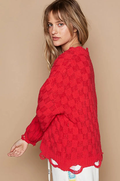 Stylish boho checkered distressed sweater in red with a relaxed fit and unique hem detail