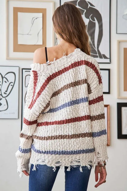 Back view of a boho striped frayed edge sweater featuring a relaxed fit and soft fabric