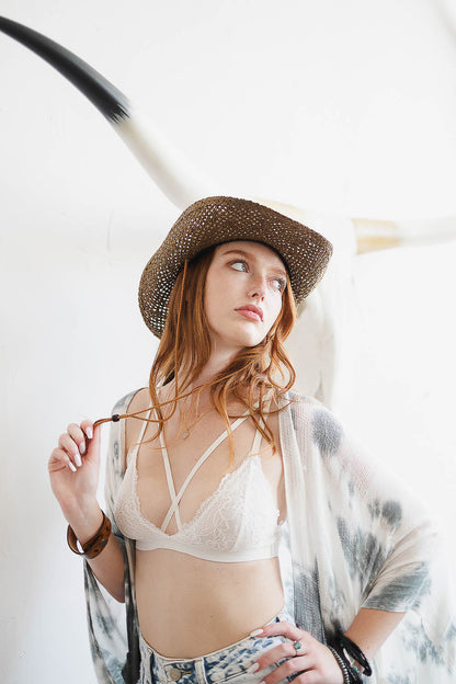 Model wearing a boho cross strap lace bralette layered under a stylish kimono and hat