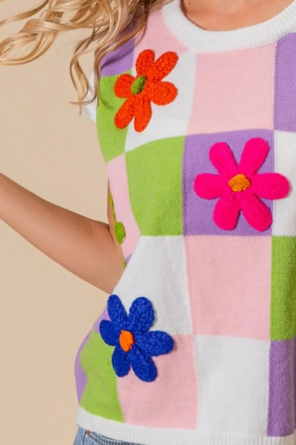 Colorful flower patch checkered sweater vest with vibrant floral appliques for a trendy look