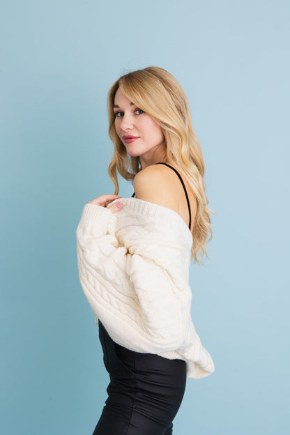 Leto Collection chunky cable knit cropped cardigan in cream worn casually with sleek black pants