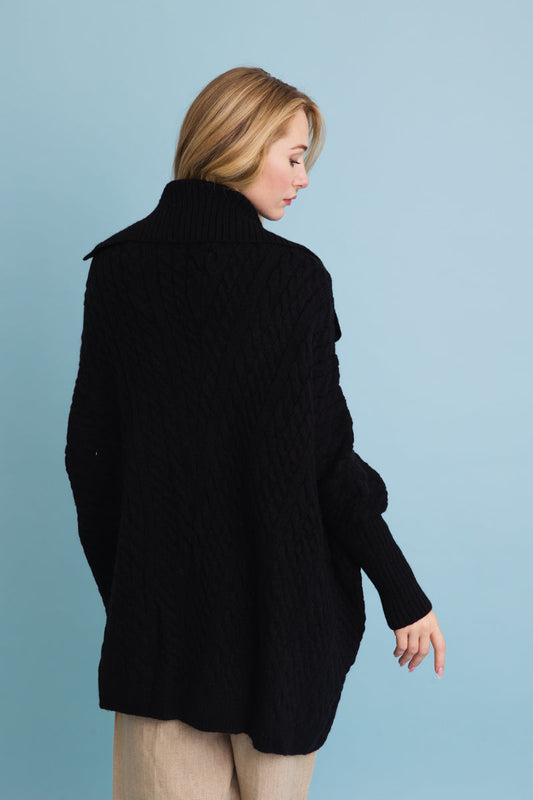 Leto Collection chunky cable knit poncho cardigan in black, showcasing a cozy oversized design