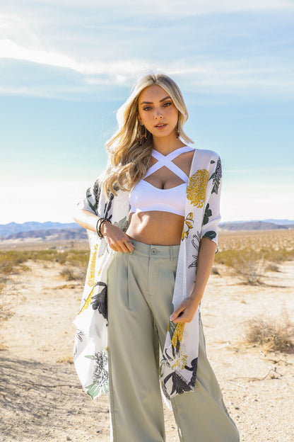 Model wearing a white boho cross strap bralette paired with a floral kimono and wide-leg pants