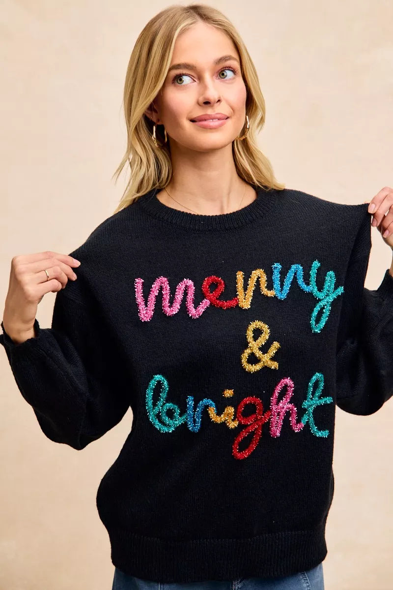Women's black tinsel lettering Christmas sweater featuring the phrase 'merry & bright' in colorful accents
