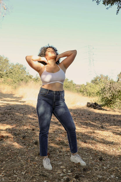 Model wearing a plus size dream catcher bralette paired with high-waisted jeans in a natural outdoor setting