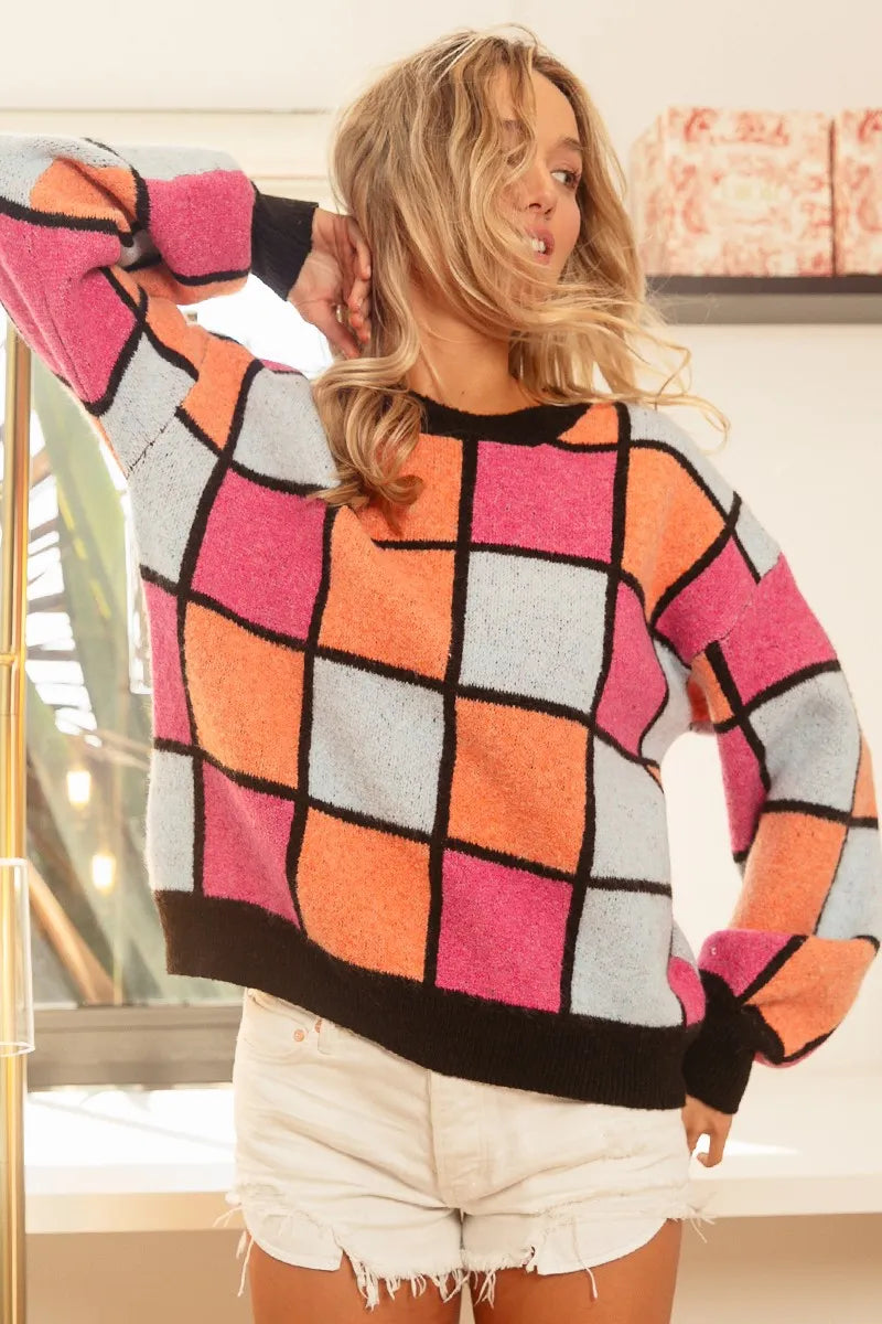 Trendy multi color checker sweater with bold patterns in pink, orange, blue, and black for a stylish look
