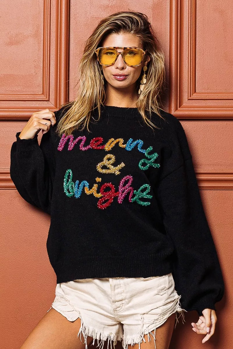 Trendsi tinsel lettering Christmas sweater featuring colorful 'Merry & Bright' design in a cozy black fabric