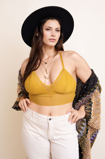 Plus size boho bralette in mustard with adjustable straps, styled with a black hat and colorful shawl.