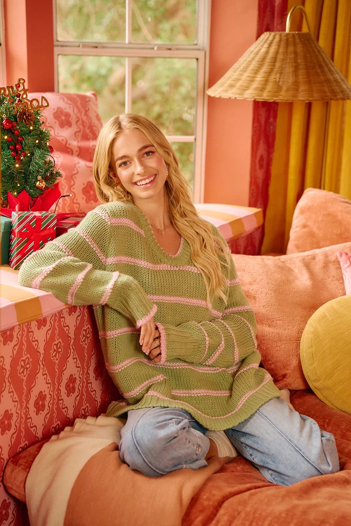 Cozy boho striped long sleeve sweater in green and pink, styled with relaxed jeans at home