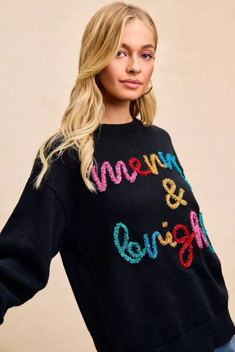 Trendsi tinsel lettering Christmas sweater in black with colorful 'Merry & Bright' design