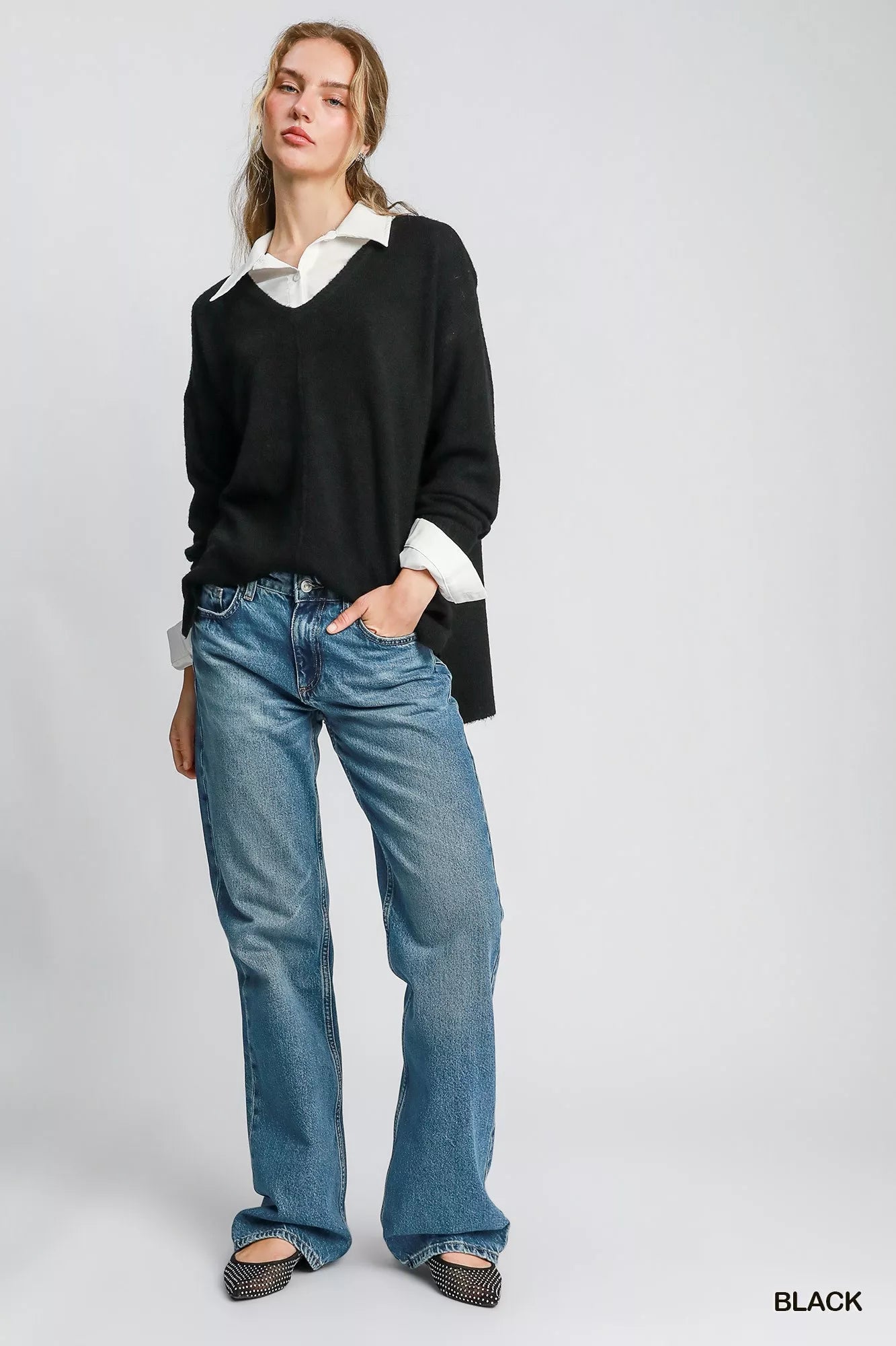 Umgee wool blend pullover sweater in black paired with a white shirt and casual jeans