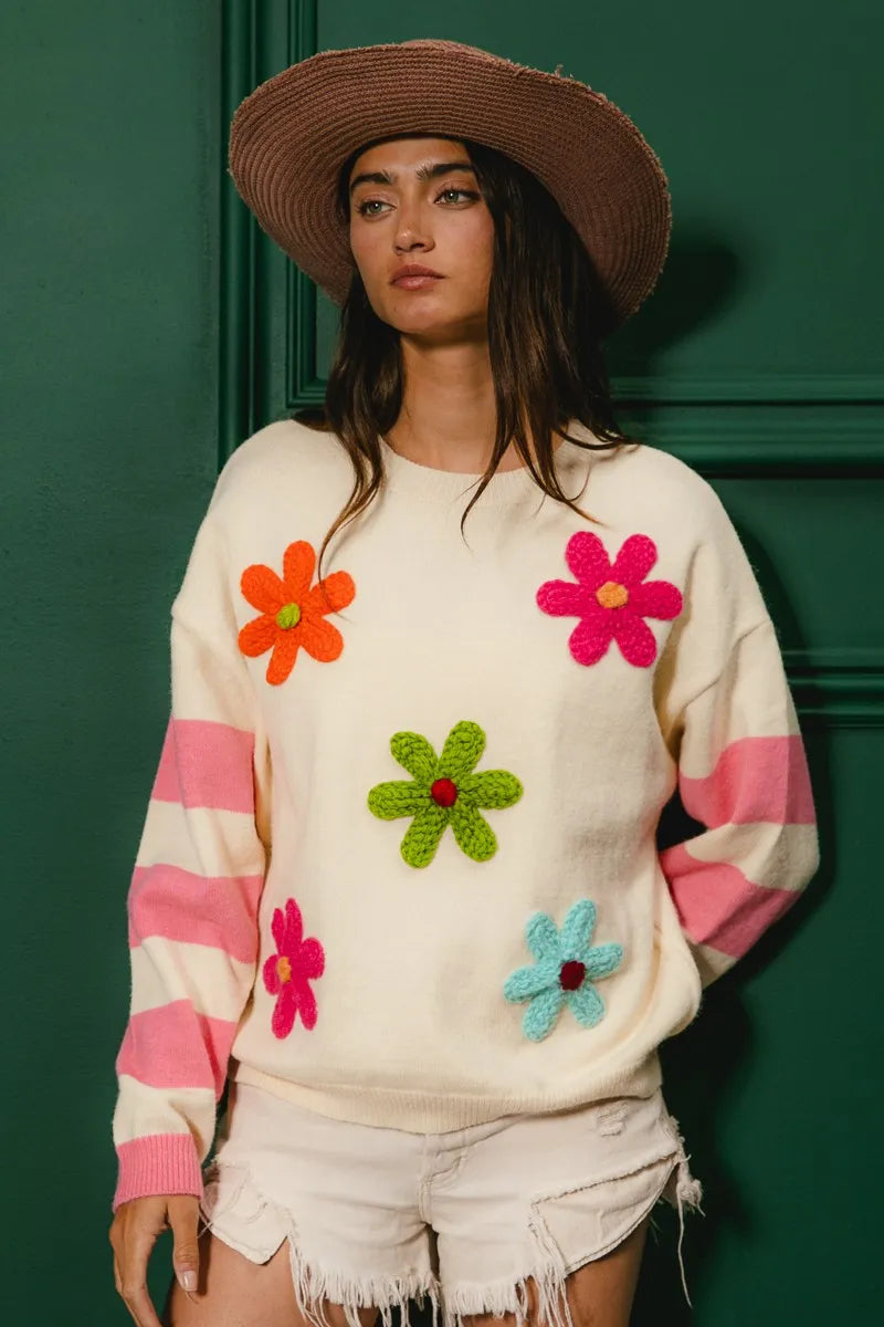 Colorful floral sweater for women with bright flower designs and striped sleeves, perfect for spring fashion.