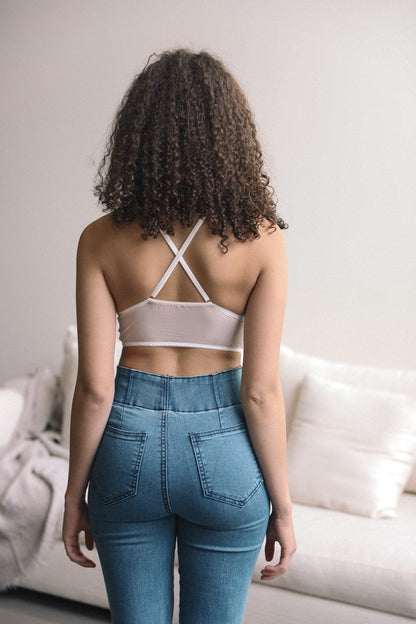 Back view of a Leto Collection boho flower embroidery high neck bralette paired with high-waisted jeans