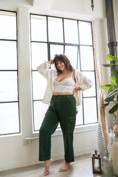 Plus size model wearing a lace longline corset bralette plus size with green pants and a white top