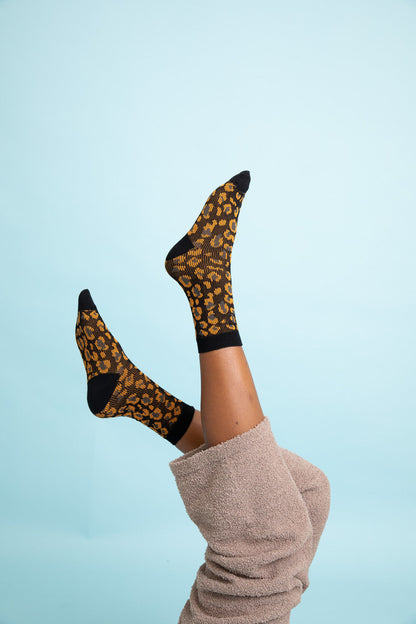 Leto Collection leopard knit socks featuring a stylish leopard print design on a black background