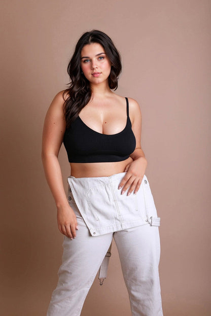 Plus size low back bralette in black, styled with light-colored pants for a chic look