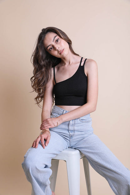 Model wearing a stylish black boho offset shoulder brami top paired with light denim jeans