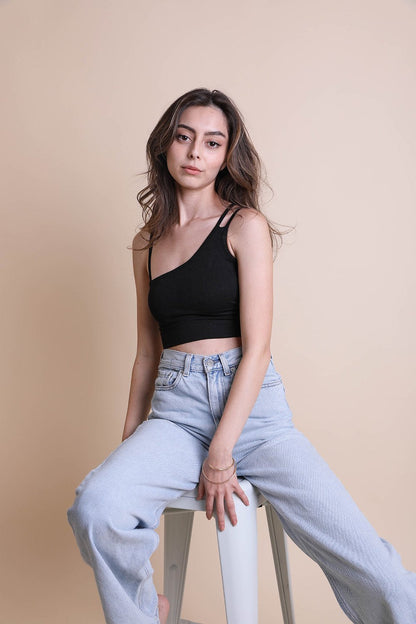 Model wearing a black boho offset shoulder brami top paired with light blue jeans for a stylish look