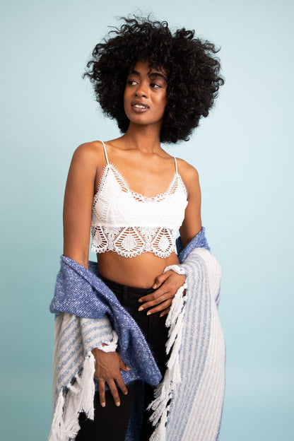 Model wearing a boho crochet bralette with intricate lace details, styled with a cozy shawl