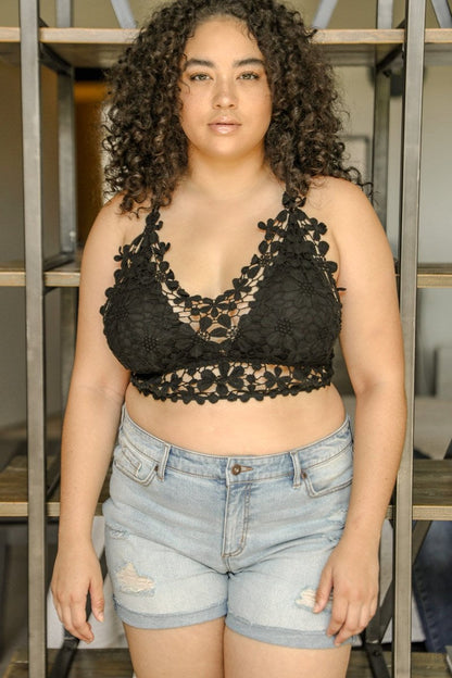Plus size crochet bralette in black with floral detailing, styled with denim shorts