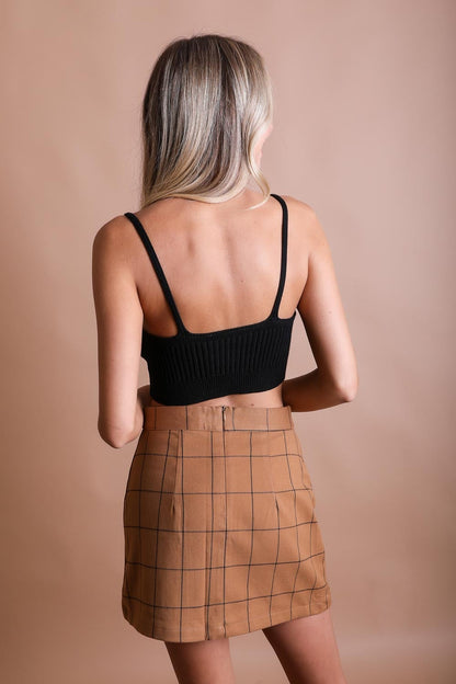 Black rib knit brami top with adjustable straps, styled with a plaid skirt