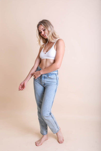White ribbed keyhole bralette styled with high-waisted light denim jeans for a casual look