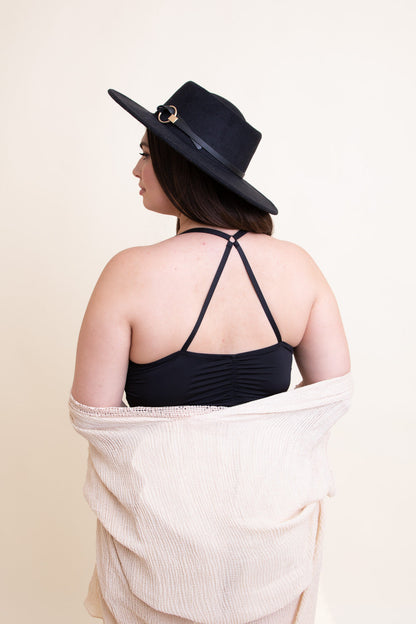 Model wearing a plus size ruched bralette with adjustable straps and a black wide-brimmed hat
