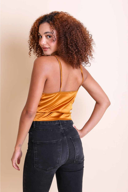 Model wearing a mustard boho satin crop top with adjustable straps paired with black jeans