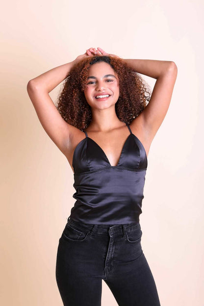 Stylish woman wearing a black boho satin crop top with thin straps and a V-neck design