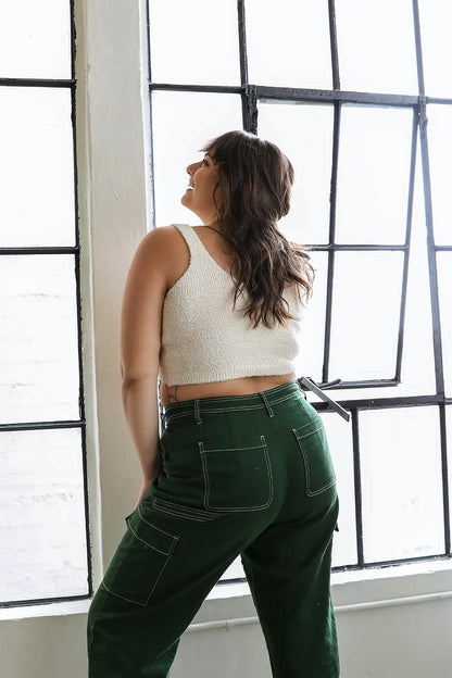 Model wearing a plus size boucle brami paired with green cargo pants in a bright room
