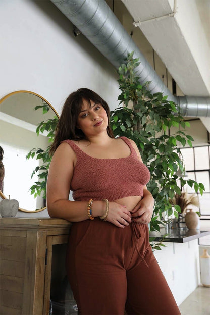 Plus size boucle brami from Leto Collection in soft pink, styled with cozy pants in a chic indoor setting