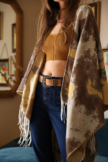 Boho suede western belt paired with a stylish outfit featuring a poncho and high-waisted jeans