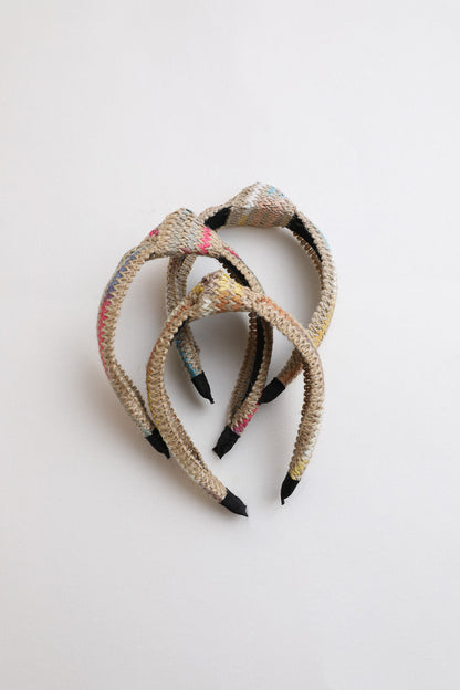 Twine woven knotted headband with natural fiber textured design.