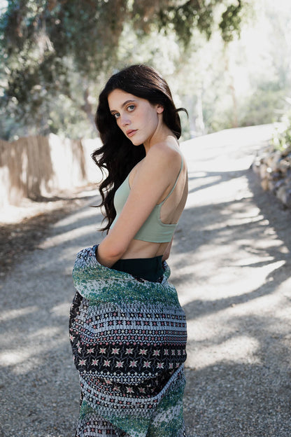 Low back seamless bralette in soft green worn casually with a blanket wrap for a stylish look