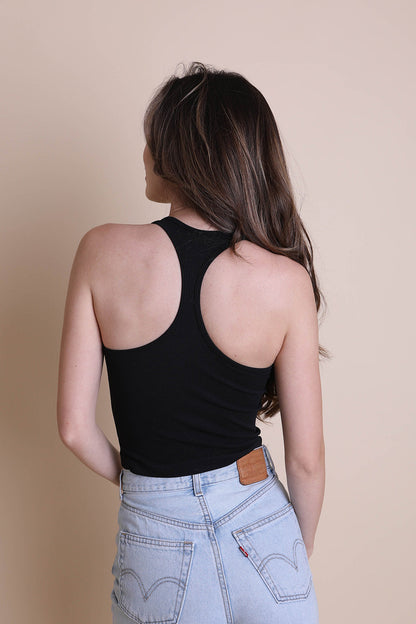 Back view of a woman wearing a black boho racerback brami paired with light denim shorts