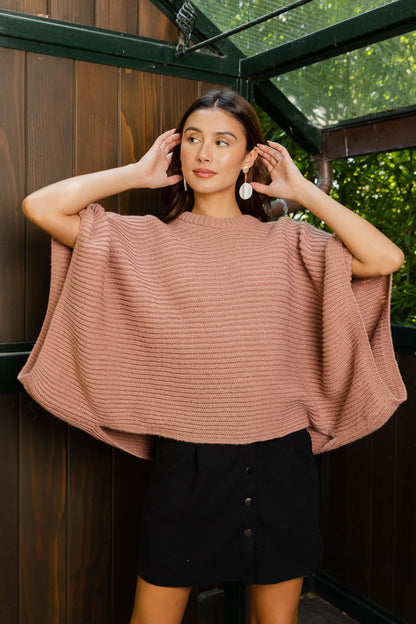 Ribbed knit poncho for women in soft pink, perfect for stylish layering and comfort