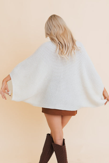 Back view of a ribbed knit poncho for women in soft white, perfect for stylish layering.