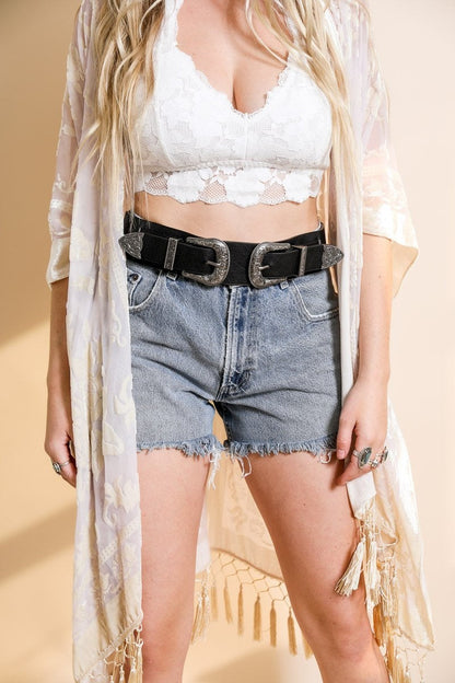 Leto Collection model wearing a western double buckle belt with high-waisted denim shorts