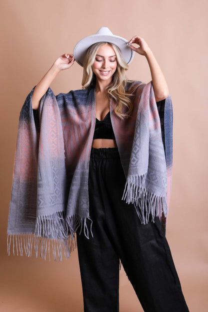 Stylish model wearing a western serape tassel shawl in gray with fringe detail, perfect for layering